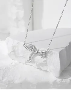Macro detail of S925 silver bow necklace with crystal tassels and cubic zirconia stones