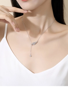 Dettaglio collana ali angelo in argento S925 con nappa e diamante su collo donna