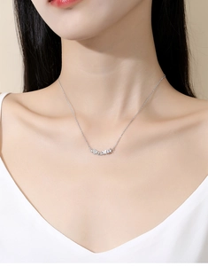 Close-up of heart and butterfly pendant with zircon inlay on silver chain necklace