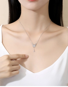 Détail du collier noeud en argent avec pendentif papillon étincelant et goutte zircon