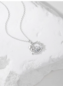 Détail d'un collier couronne en argent 925 avec lune et étoiles sur un socle en pierre