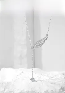 Dettaglio macro della collana ad ala d'argento con zirconi e ciondolo a nappa