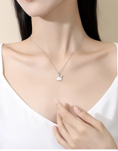Gros plan du collier feuille de ginkgo en argent S925 avec nacre blanche sur un modèle