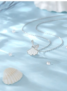 Détail du pendentif feuille de ginkgo en argent s925 avec nacre blanche sur fond d'eau