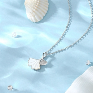 Collier feuille de ginkgo en argent S925 avec pendentif en nacre sur fond d'eau bleue
