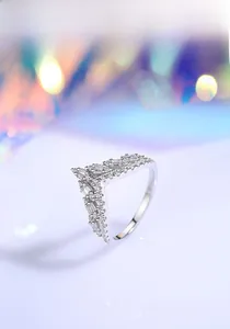 Macro detail of V-shaped crown ring with baguette and round cut diamonds in S925 silver