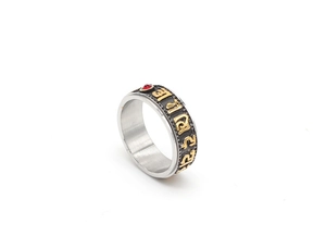 Macro shot of titanium steel mantra ring with golden scripture and red stone inlay