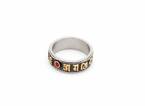 Macro shot of rotatable stainless steel ring featuring golden mantras and red inlay