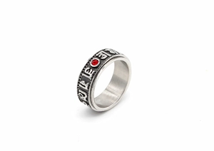 Macro view of rotating spinner ring with Six-Word Mantra and red gemstone detail