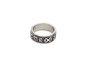 Macro detail of rotating stainless steel ring with vintage Tibetan mantras engraving