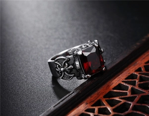 Macro shot of retro Viking axe ring featuring a deep red gemstone and antique silver finish