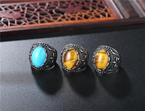Detail of vintage signet rings featuring turquoise and tiger eye stones in antique silver