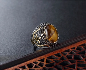 Detailed macro shot of a vintage punk ring with tiger eye stone and gold-plated details