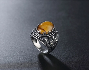 Macro detail of men's vintage tiger eye ring with intricate engraved scrollwork