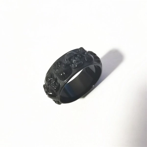Détail macro d'une bague punk gothique à tête de mort en acier inoxydable noir mat