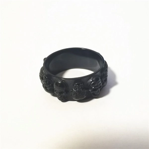 Vue macro de la bague gothique noire mate avec motifs détaillés de crânes en relief