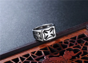 Macro side view of polished stainless steel biker ring with engraved iron cross patterns