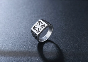 Macro shot of silver retro titanium steel signet ring with iron cross relief