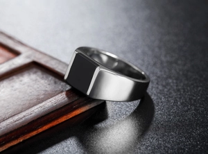 Macro side view of a men's titanium steel signet ring with a black agate inlay