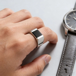 Minimalist men's titanium steel ring with black onyx inlay worn with business watch