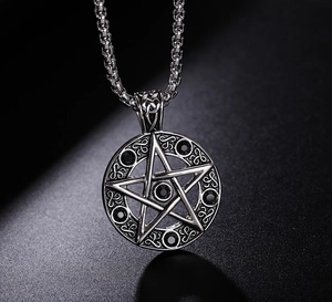 Vue macro du collier pentagramme avec pierres noires sur un fond sombre texturé