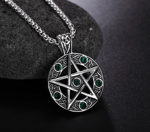 Détail du collier pentagramme rétro en acier avec pierres vertes sur un fond de pierre grise