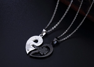 Detailed view of silver and black stainless steel heart pendant with clover engraving