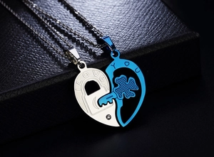 Detail shot of blue heart key and silver lock couple necklaces on leather box