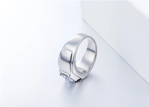 Macro shot of silver men's signet ring featuring a polished rectangular surface and side gemstone