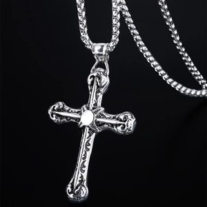 Collana con pendente a croce vintage gotica e strass per uomo su sfondo nero riflettente