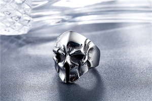 Macro shot of retro Spartan helmet skull ring in dark titanium steel on leather surface
