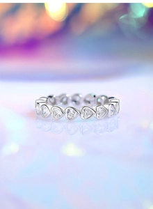Close-up of S925 sterling silver ring with heart-shaped cubic zirconia stones on reflections