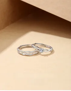 Macro degli anelli di coppia in argento S925 che mostrano il diamante singolo e il marchio S925