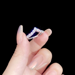 S925 Sterling Silver V-shaped ring with pavé-set zircons held against a black background