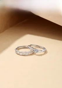 Dettaglio degli anelli di coppia in argento S925 con trama intrecciata e diamante brillante