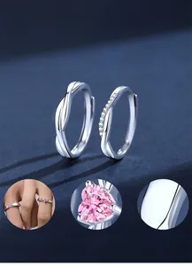 Detail of 925 sterling silver couple rings with pink heart zirconia and polished mobius design