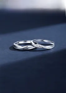 Detail of 925 sterling silver couple rings with wavy zircon inlay and twisted band