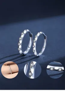 Macro details of wave-shaped S925 silver hoop earrings with cubic zirconia stones