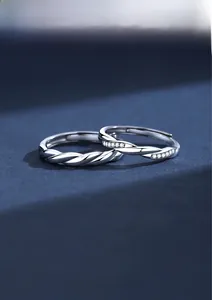 Detailed view of intertwined S925 silver couple rings with twisted design and zircons