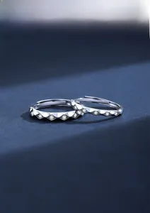 Detail view of S925 silver wavy rings with small white stones on a blue background