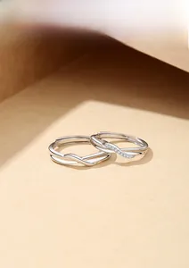 Detail of interlocking Mobius silver couple rings with sparkling pavé stones and adjustable band