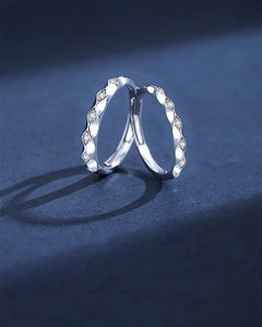 Detailed shot of wave-textured S925 silver couple rings with small inlaid zircons