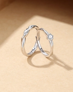 Vista macro de anillos de pareja en plata S925 con diseño de nudo y banda ajustable