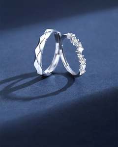 Macro shot of silver sterling couple rings with wavy texture and star zircon details