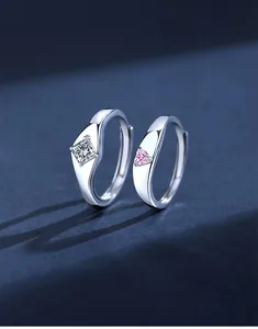 Close-up of S925 silver couple rings with princess cut diamond and pink heart gemstone