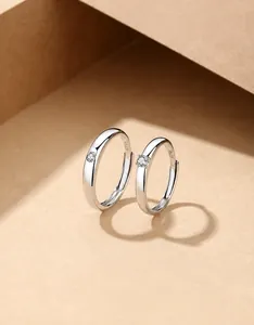 Close-up of S925 silver couple rings featuring a round zircon inlay and polished finish