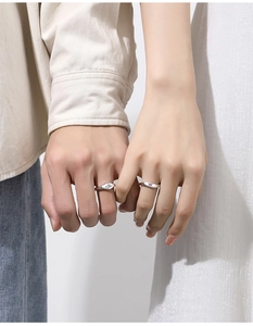 Detail of S925 silver couple rings with square and pink heart gems on hands