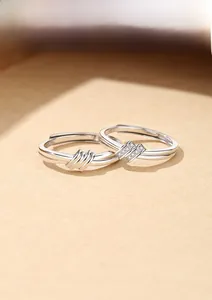 Detail of S925 sterling silver knotted couple rings with sparkling pavé zircon stones