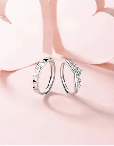 Detail of crown-shaped silver couple rings with shimmering diamonds and geometric facets