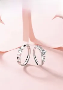 Macro detail of silver couple rings featuring geometric relief and wave diamond settings